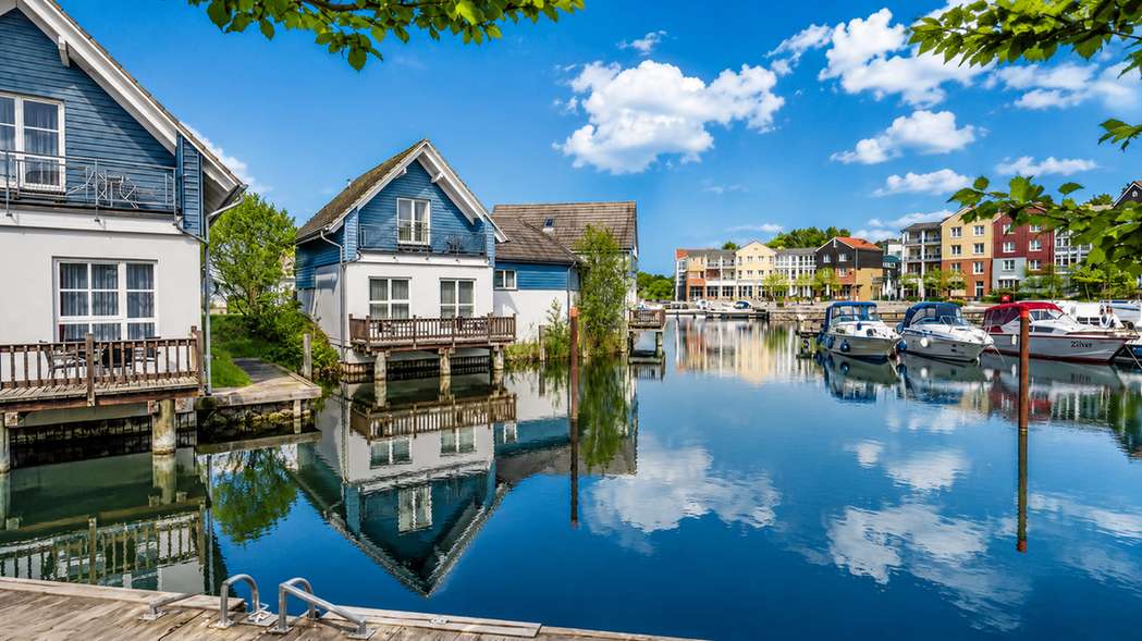 Waterfront houses and boats at Marina Wolfsbruch under a blue sky