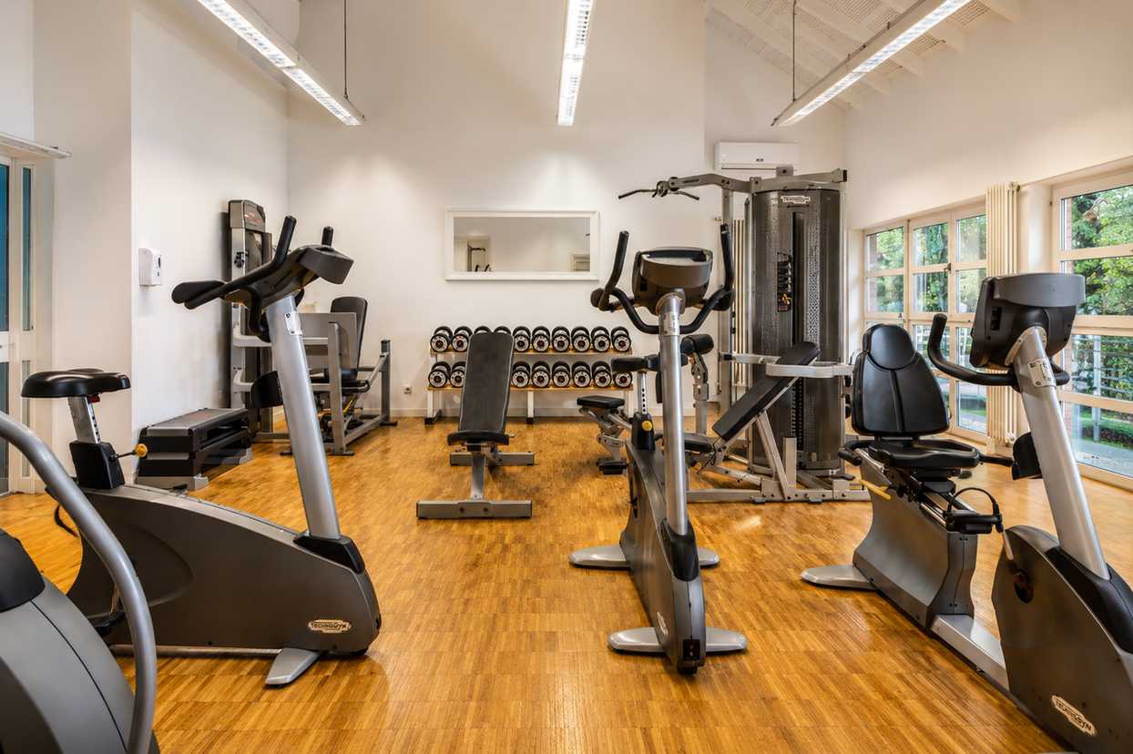 Modern fitness studio with cardio equipment and free weights
